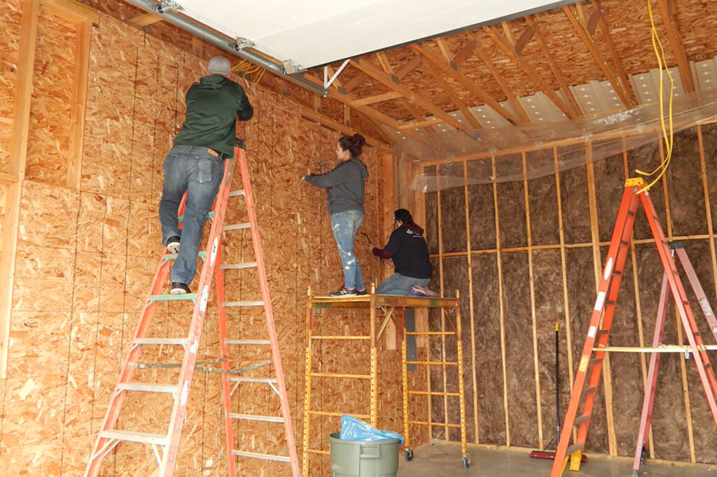 three people working on construction of garage