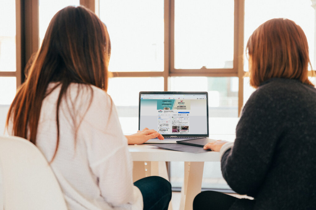 two women using laptop